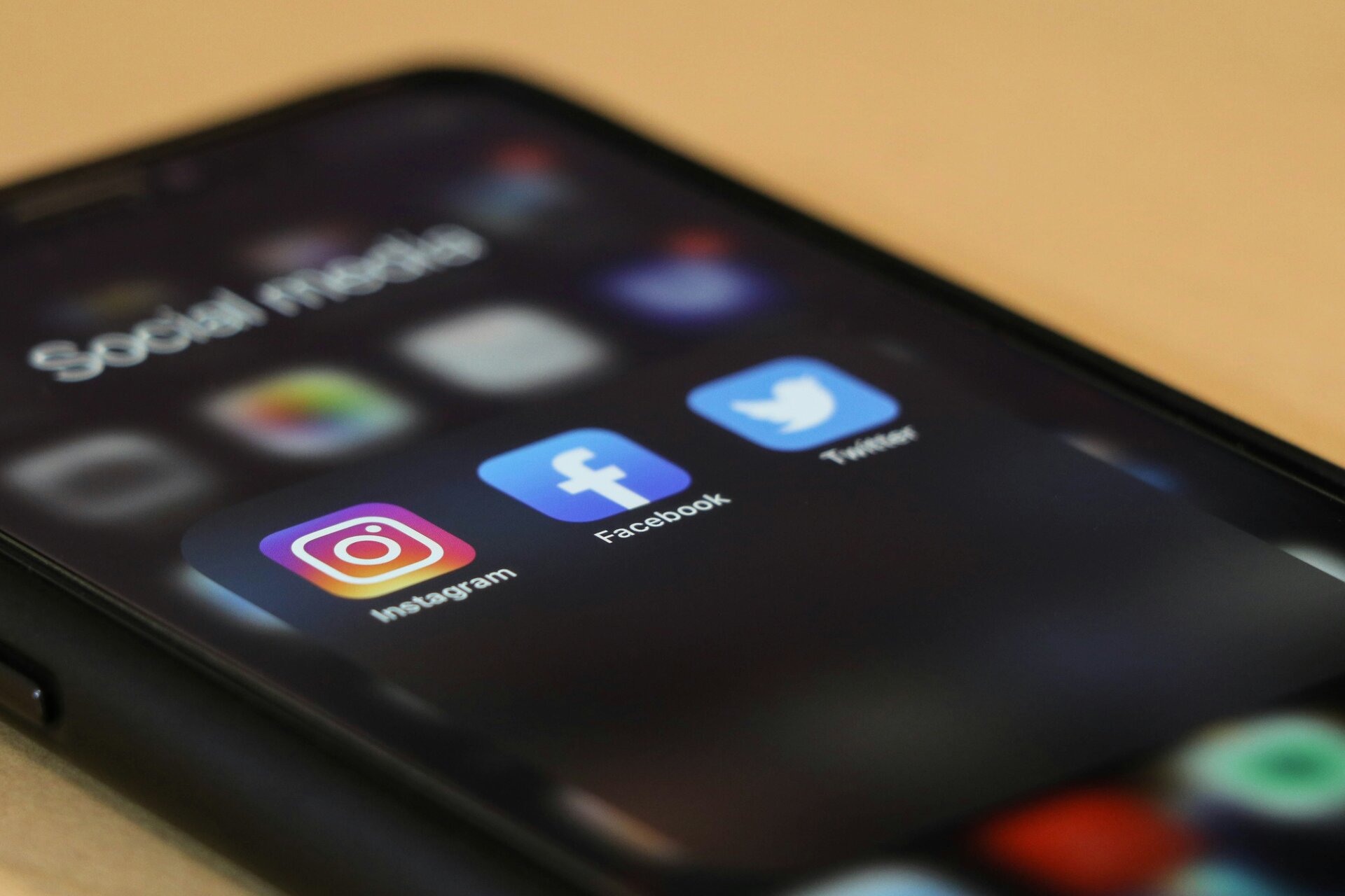 Smartphone-Bildschirm mit geöffnetem Social-Media-Ordner, der die Icons von Instagram, Facebook und Twitter zeigt